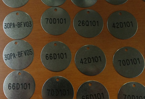 deep engraved text on valve identification tag 